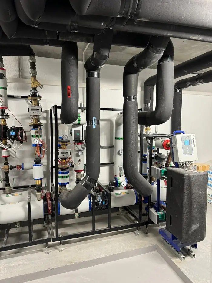 Sous-station de chauffage collectif avec circulateurs, compteurs d'énergie et tuyauterie isolée
