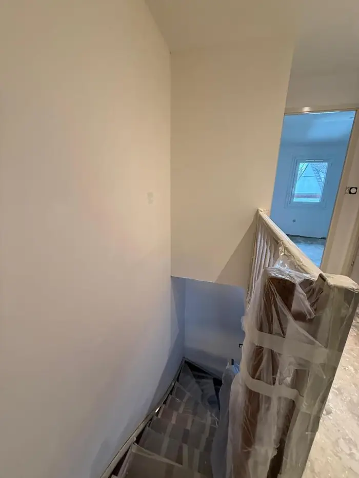 Cage d'escalier en travaux avec escalier et rampe protégés