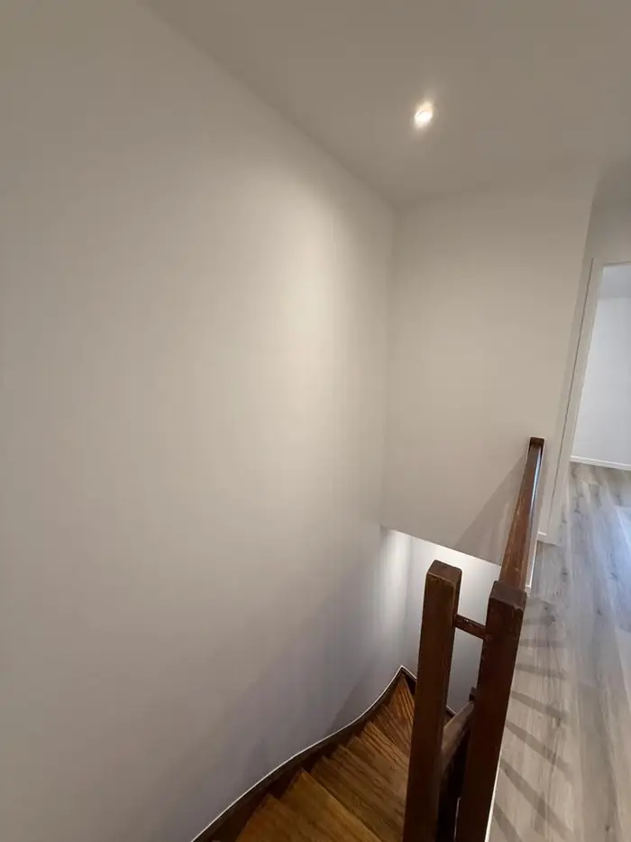 Cage d'escalier rénovée, escalier et rampe en bois d'origine conservés