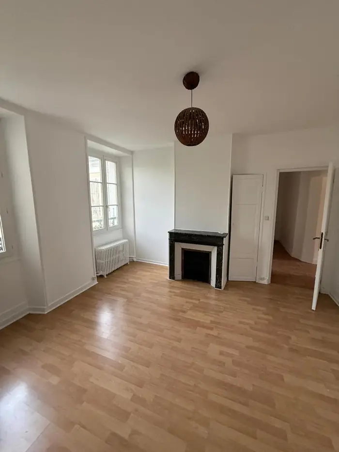 Chambre terminée avec murs blancs, cheminée en marbre et parquet