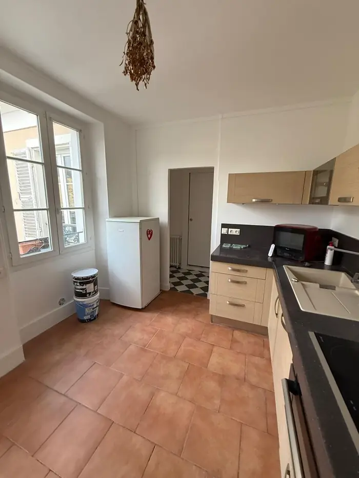 Cuisine terminée : murs et plafond repeints en blanc, sol en tomettes