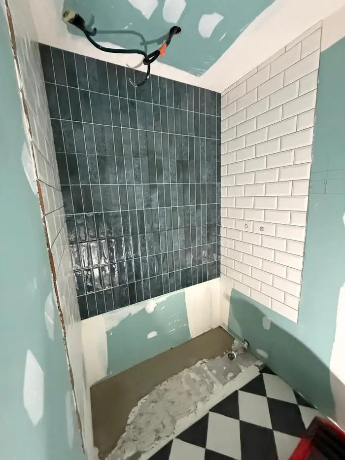 Douche en cours de carrelage, zellige bleu nuit et carreaux métro blancs