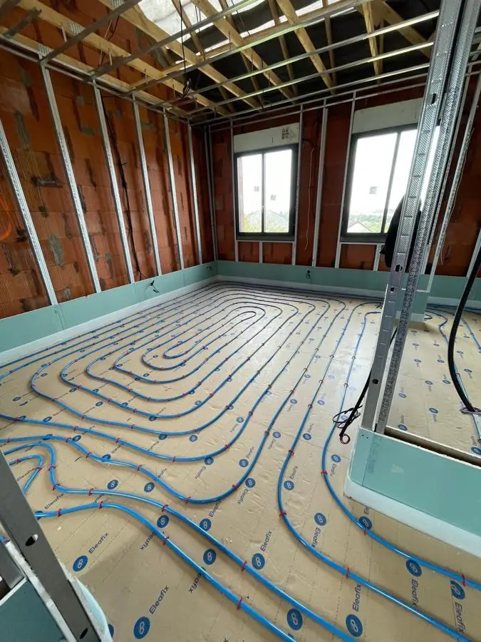 Plancher chauffant hydraulique posé en spirale sur isolant, avant la chape