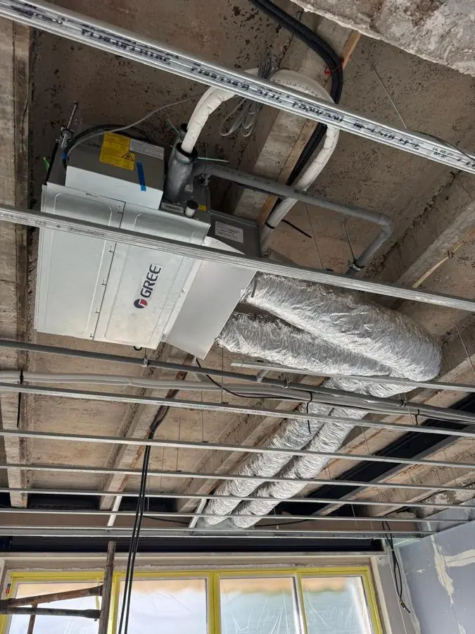 Unité de climatisation gainable Gree suspendue sous dalle avec gaines de soufflage isolées, avant pose du faux plafond